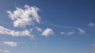Açık beyaz bulutlar parlak mavi bir gökyüzünde uçar. Güneşli bir yaz öğleden sonrasında gökyüzü açık. Bahar bulutları arka planı. Boşluğu kopyala