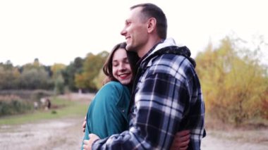 Çekici kadın ve yakışıklı erkek birlikte zaman geçirip sonbahar parkında sarılıyorlar. Ormanda Aşk Hikayesi. 