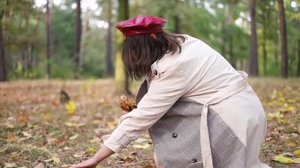 Happy Young Woman Wearing Red Beret Picking Fallen Maple Leaves — Stock Video