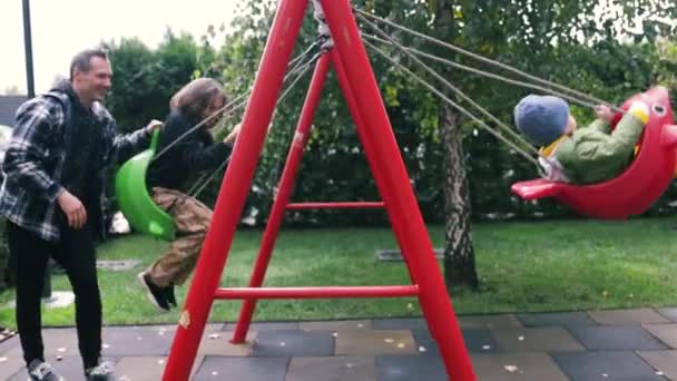 아버지는 행복한 아이가 놀이터에서 스윙에 아이들의 엔터테인먼트 주말에 사람들의 시절의 — 비디오