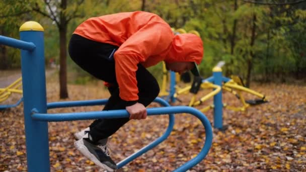 Jovem Homem Exercitando Livre Campo Esportes Bombeia Músculos Usando Equipamentos — Vídeo de Stock
