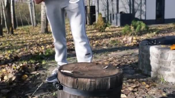 男は秋の森で斧で木を切っている — ストック動画
