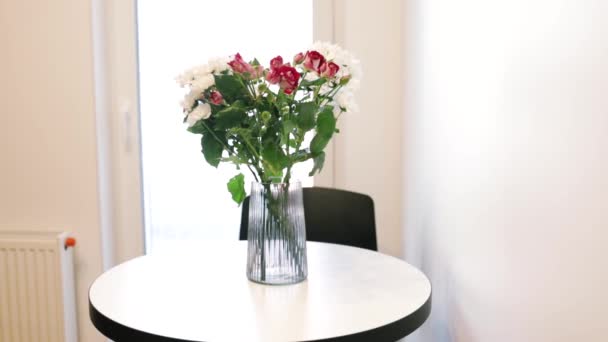 Bukiet Czerwono Białych Kwiatów Wazonie Przeciwko Białej Ścianie Kuchni — Wideo stockowe