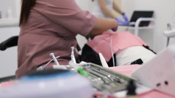 Diş Kliniğinde Koruyucu Maskeli Iki Kadın Doktor Hastaya Servis Yapıyor — Stok video