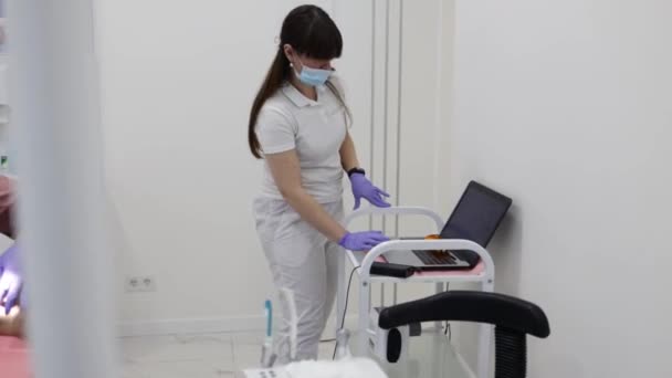 牙科医生在牙科诊所检查男病人时使用手提电脑 — 图库视频影像