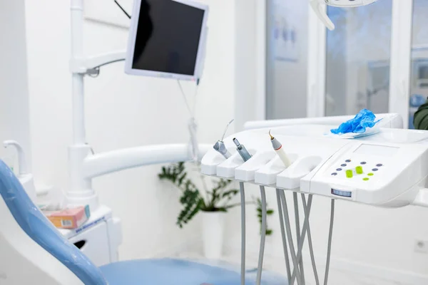 Modern dental practice. Dental chair and other accessories used by dentists in blue, copper light.