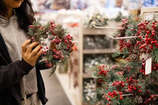 Woman choosing christmas decoration in store. Christmas and winter holidays concept