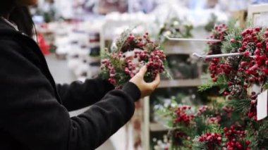Mağazada Noel süsü seçen bir kadın. Noel ve kış tatili konsepti