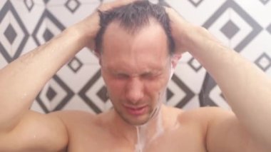 Beyaz bir adam evdeki banyoda duş alıyor. Modern banyoda duştaki atletik adam..