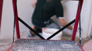 Eller sıva ustası inşaat işçisi mala vuruyor, duvara sıva yapıyor, yakınlaştırıyor..