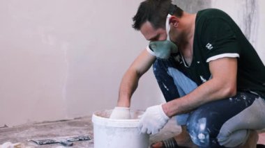 Eller sıva ustası inşaat işçisi mala vuruyor, duvara sıva yapıyor, yakınlaştırıyor..