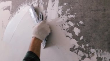 Eller sıva ustası inşaat işçisi mala vuruyor, duvara sıva yapıyor, yakınlaştırıyor..