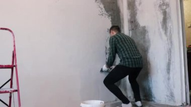 Eller sıva ustası inşaat işçisi mala vuruyor, duvara sıva yapıyor, yakınlaştırıyor..