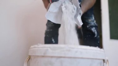 Eller sıva ustası inşaat işçisi mala vuruyor, duvara sıva yapıyor, yakınlaştırıyor..