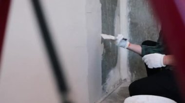 Eller sıva ustası inşaat işçisi mala vuruyor, duvara sıva yapıyor, yakınlaştırıyor..