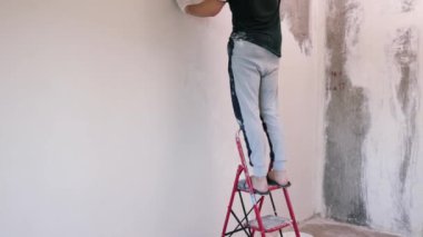 Eller sıva ustası inşaat işçisi mala vuruyor, duvara sıva yapıyor, yakınlaştırıyor..