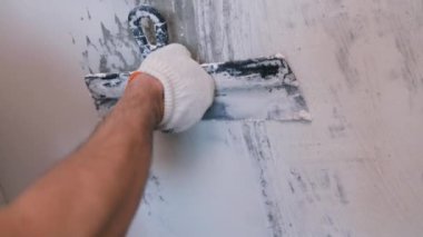 Eller sıva ustası inşaat işçisi mala vuruyor, duvara sıva yapıyor, yakınlaştırıyor..