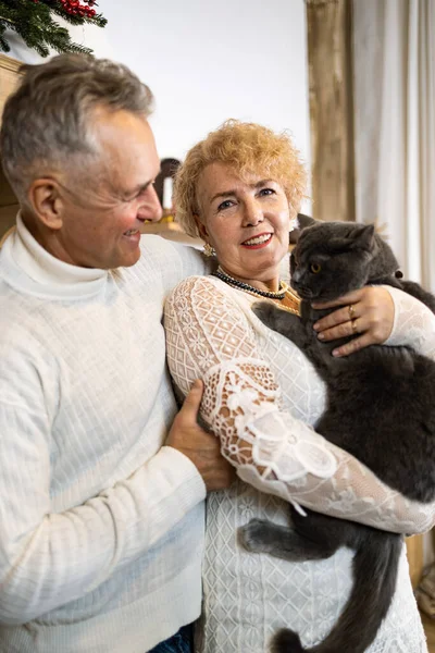 Senior couple stroking a cat as a pet for companionship and against loneliness.