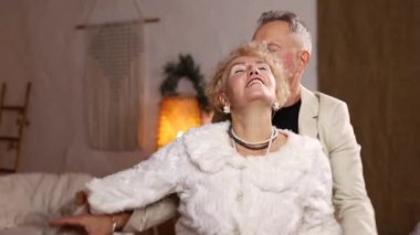 Noel ağacının önünde dans eden olgun bir çift..