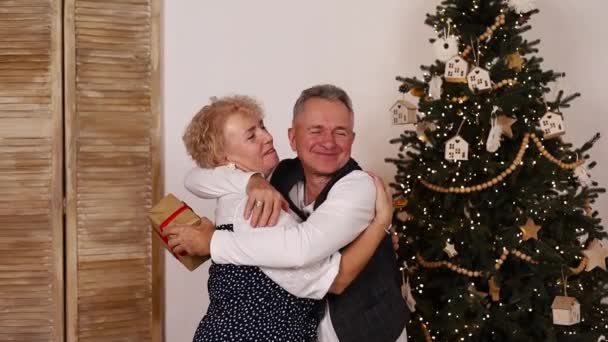 穿着暖和毛衣的老夫妇 白种人男人蒙着老太太的眼睛 送给她一份惊喜的礼物 爱旧浪漫的异性夫妇一起庆祝圣诞 — 图库视频影像