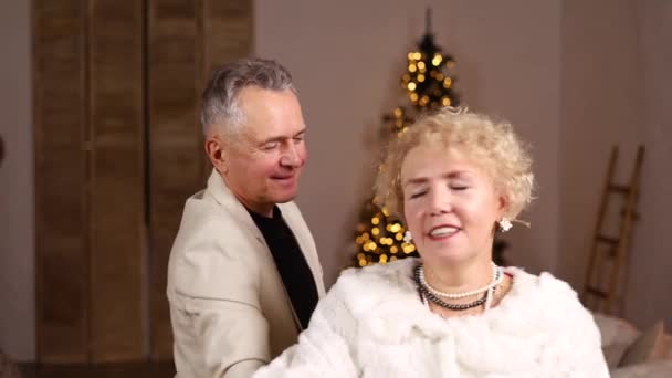 Κομψό Ώριμο Ζευγάρι Που Χορεύει Στο Σπίτι Μπροστά Από Χριστουγεννιάτικο — Αρχείο Βίντεο