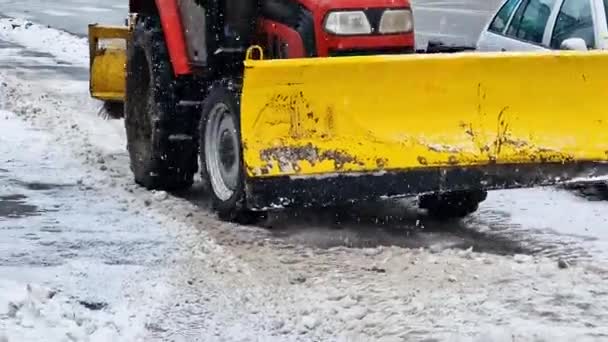 黄色い機械は雪の後のウクライナの舗装からの速い速度のバケツが付いている雪をシャベルします — ストック動画