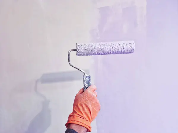 Roller Brush Painting, Worker painting on a steel wall surface using a roller brush for protection and corrosion.