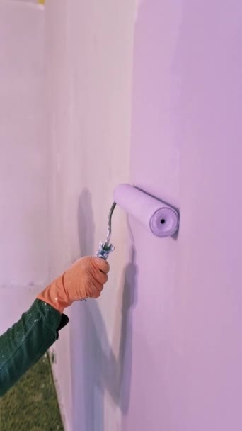 缝纫工手握滚筒涂紫罗兰色油漆新居家客厅墙壁 — 图库视频影像