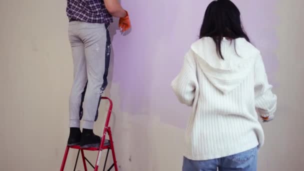 Ζευγάρι Κρατώντας Ρολό Θάμνος Εφαρμογή Βιολετί Χρώμα Χρώμα Νέο Σπίτι — Αρχείο Βίντεο