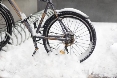 Kışın bisiklet parkı, karla kaplı bisiklet sıraları.