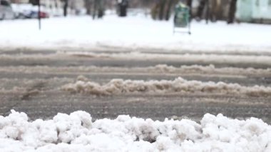 Şiddetli kar yağışı sırasında şehir yolları. Arabalar kış çamurunda ve karda yol alır.