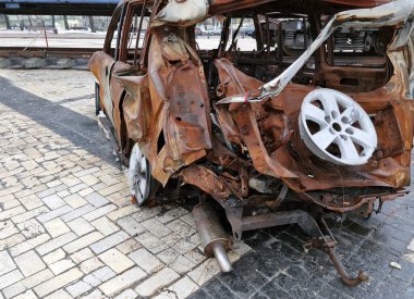 Ukrayna 'da savaş. 2022 Rus istilası Ukrayna. Yıkılmış bir sivil araba yolun kenarında duruyor. İnsan yok. Savaş Suçları.