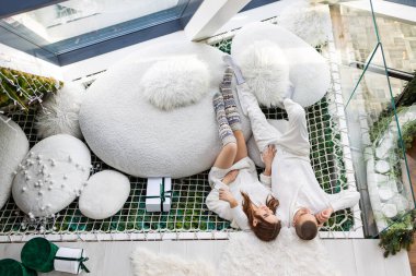 Mutlu bir adamın sevgilisine sarılmasının ve evde birlikte yatmasının, İskandinav tarzı bir yatak odasında sevişen bir çiftin manzarası.. 