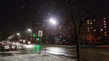 Eski şehir caddesinde kışın gece vakti düşen karlar sokak lambasıyla aydınlatılıyor. Kar yağışı, kar fırtınası ve güçlü rüzgâr..