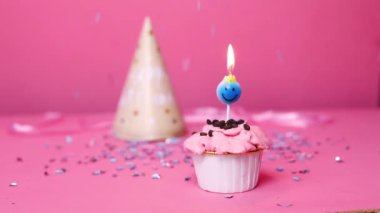 Pastel pembe arka planda yanan renkli mumlu doğum günü pastası. Doğum günün kutlu olsun. Kekin üzerine mum yak..