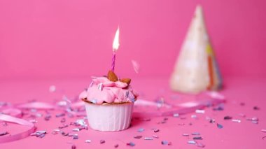 Pastel pembe arka planda yanan renkli mumlu doğum günü pastası. Doğum günün kutlu olsun. Kekin üzerine mum yak..