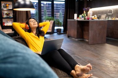 Ara veriyoruz. Gülümseyen, gözlüklü genç Asyalı kadın koltukta dinleniyor, bilgisayarını kullanıyor, mutlu bir milenyum kadını arkasına yaslanıyor, işini seviyor, kendini mutlu hissediyor..