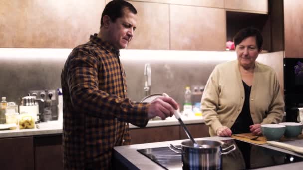 Oudere Echtpaar Koken Soep Keuken Sluiten Van Mens Roeren Soep — Stockvideo