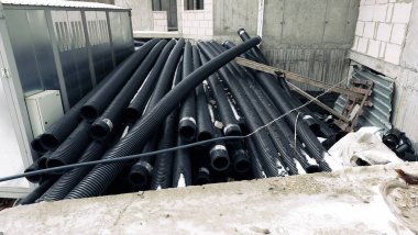 PVC kıvrımlı boru siyah renk yerde yatıyor..