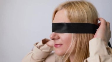 Gözleri bağlı genç bir kız yatakta oturuyor, çift ön sevişmeden zevk alıyor. Gözlerinde bdsm fetişi siyah kurdele ile erotik rol yapma oyunu oynuyor.. 