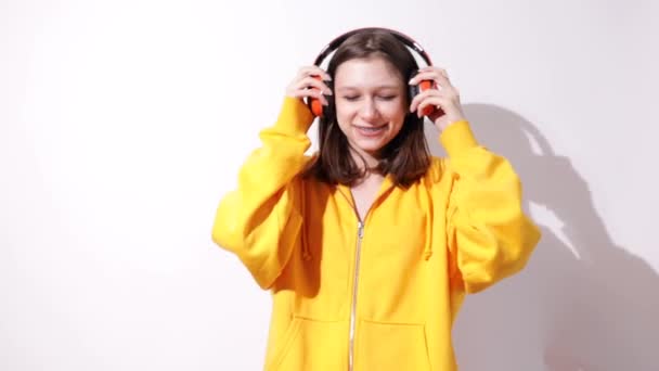 Meisje Tiener Het Geel Luisteren Naar Muziek Hoofdtelefoon Witte Achtergrond — Stockvideo