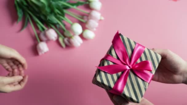 Young Man Gives Girl Gift Box Pink Background Flat Lay — Stock Video