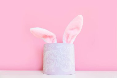 Pembe arka planda geniş bir pankart. Paskalya için online alışveriş, alışveriş ve tatil için satış kavramı. Tavşan kulaklı hediye paketi..