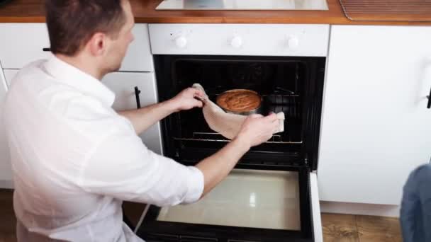年轻人从电炉里拿着烤盘和好吃的开胃蛋糕 现代家庭中的家务活 烹调概念 — 图库视频影像