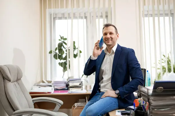 Portrait of a businessman talking on the phone while sitting in an office