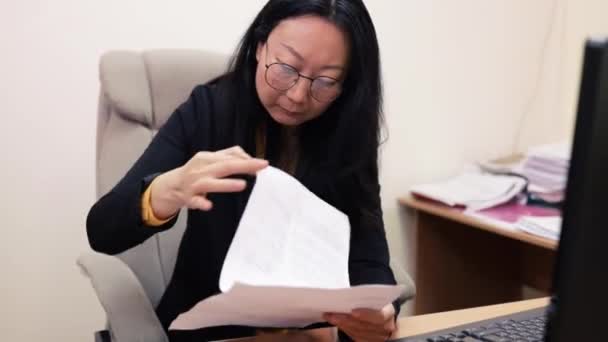 在办公室里用现代笔记本电脑打字的商业女性非常引人注目 迷人的亚洲女经理 戴着眼镜 坐在电脑屏幕桌前 亚洲妇女公司的正式员工 — 图库视频影像