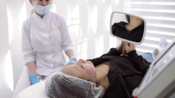 Aziatische Vrouw Patiënt Kijken Spiegel Gezicht Huidreiniging Procedure Praten Met — Stockvideo