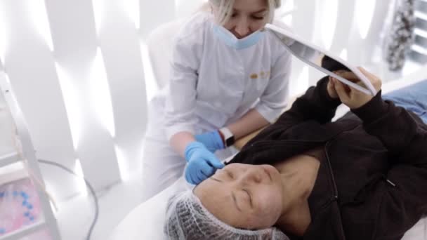 Aziatische Vrouw Patiënt Kijken Spiegel Gezicht Huidreiniging Procedure Praten Met — Stockvideo