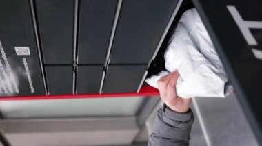 Açık havada akıllı telefon kullanan bir adamın otomatik posta kutusundan paket aldığını gösteren dikey video. Modern dağıtım teknolojileri kavramı.