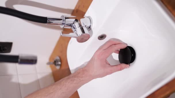 管子工修理水池的废渣收集器 一个男人的手在浴室的水槽下修理装置 手工艺和建筑概念 垂直录像 — 图库视频影像